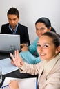 Cheerful business woman showing okay at meeting