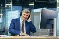 Businessman on a break listening to music and dancing with big headphones, senior and experienced gray-haired man working Royalty Free Stock Photo