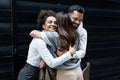 Cheerful businessman and businesswomen hugging each other in front of office building. Colleagues hug colleague who change her job Royalty Free Stock Photo