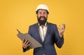 cheerful businessman in helmet looking at new drawings and making notes, builder work Royalty Free Stock Photo