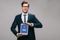 Cheerful businessman holding digital tablet with facebook app on screen isolated