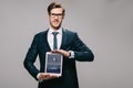 Cheerful businessman holding digital tablet with tumblr app on screen isolated