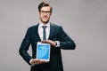 Cheerful businessman holding digital tablet with twitter app on screen isolated