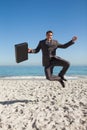 Cheerful businessman jumping on the beach Royalty Free Stock Photo