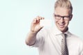 Cheerful businessman presenting white empty card.