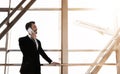 Cheerful businessman standing in airport, talking on phone Royalty Free Stock Photo