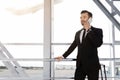 Cheerful businessman standing in airport, talking on phone Royalty Free Stock Photo