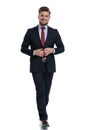 Cheerful businessman stepping and adjusting his jacket Royalty Free Stock Photo