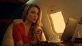 Cheerful businesswoman chatting online on private jet closeup. Remote workplace