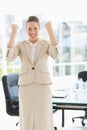 Cheerful businesswoman clenching fists in office Royalty Free Stock Photo