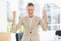 Cheerful businesswoman clenching fists in office Royalty Free Stock Photo