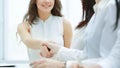 Cheerful businesswoman and client handshaking, sitting at the table Royalty Free Stock Photo