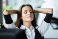 Cheerful businesswoman dreaming at workplace. Female office worker takes break after job done. Business lady relaxing at