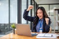 Cheerful businesswoman is looking at her laptop screen with a happy face, receiving good news online Royalty Free Stock Photo