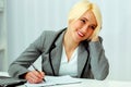 Cheerful businesswoman sitting at the table on her workplace Royalty Free Stock Photo