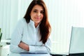 Cheerful businesswoman sitting at the table on her workplace Royalty Free Stock Photo