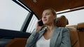 Closeup relaxed businesswoman calling mobile phone in luxury car.