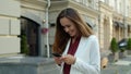 Cheerful businesswoman typing message on mobile phone outdoors Royalty Free Stock Photo