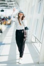 Cheerful businesswoman waiting for her flight at airport. Young woman at the airport. Woman is waiting her flight in