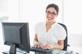 Cheerful businesswoman working at her desk looking at camera Royalty Free Stock Photo