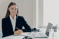 Cheerful bussiness woman sitting at her workplace in office Royalty Free Stock Photo