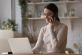 Cheerful busy freelance professional woman working at home kitchen table