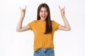 Cheerful, carefree emotive happy woman feeling wild and free, raising hands showing rock-n-roll, heavy metall sign Royalty Free Stock Photo