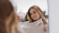 Cheerful carefree happy young girl shopper shopaholic woman smiling lady consumer female blonde trying on new sweater