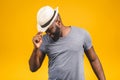 Cheerful carefree young dark-skinned african american man with trendy hat smiling, posing isolated against yellow wall with copy Royalty Free Stock Photo
