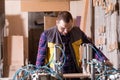 Cheerful carpenter operating woodworking machine in dusty workshop