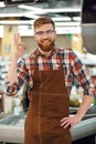 Cheerful cashier man on workspace in supermarket shop. Royalty Free Stock Photo