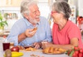 Cheerful caucasian couple having breakfast at home. Senior people relaxed and happy, enjoying food and drink Royalty Free Stock Photo