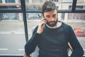 Cheerful caucasian man in black pullover using mobile phone application for mobile blogging. Confident young hipster guy Royalty Free Stock Photo