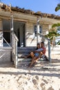 Cheerful caucasian young couple smiling and relaxing on wooden steps outside cottage, copy space Royalty Free Stock Photo