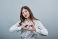 Cheerful caucasian young woman in fashion white shirt doing shape of heart Royalty Free Stock Photo