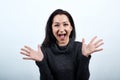 Cheerful caucasian young woman spreads hands, smiling with opened mouth