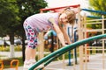 A cheerful, charming little girl climbed the iron stairs to the playground on a sunny day. A happy, smiling four-year-old girl