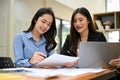 Cheerful two Asian young businesswomen working together on sales and financial report Royalty Free Stock Photo