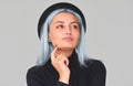 Cheerful and charming young teenager woman with blue hair wearing black apparel and hat, smiling, looking up. Cute positive female Royalty Free Stock Photo