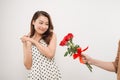 Cheerful charming young woman receiving bunch of flowers from her boyfriend over white background Royalty Free Stock Photo