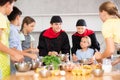 Cheerful chefs in black uniform conducting culinary masterclass for children Royalty Free Stock Photo