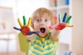 Cheerful child boy showing hands painted in bright colors. Focus on color palms Royalty Free Stock Photo