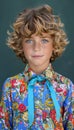 Cheerful child with curly hair smiling and gazing directly at the camera with joy