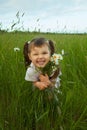 Cheerful child embraces wild flowers