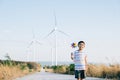 Boy& x27;s playful fascination near wind turbines holding a pinwheel toy Royalty Free Stock Photo