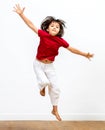 Cheerful child enjoying jumping with wide arms to express happiness