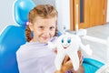 Cheerful child holding a toy tooth