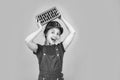 cheerful child laborer using building uniform and brick, building