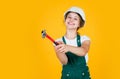 Cheerful child laborer using building uniform and hammer tool, tool shop