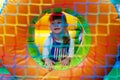 A cheerful child is playing in an inflatable castle. Happy little girl on a rubber inflatable slide. Happy childhood.Entertainment Royalty Free Stock Photo